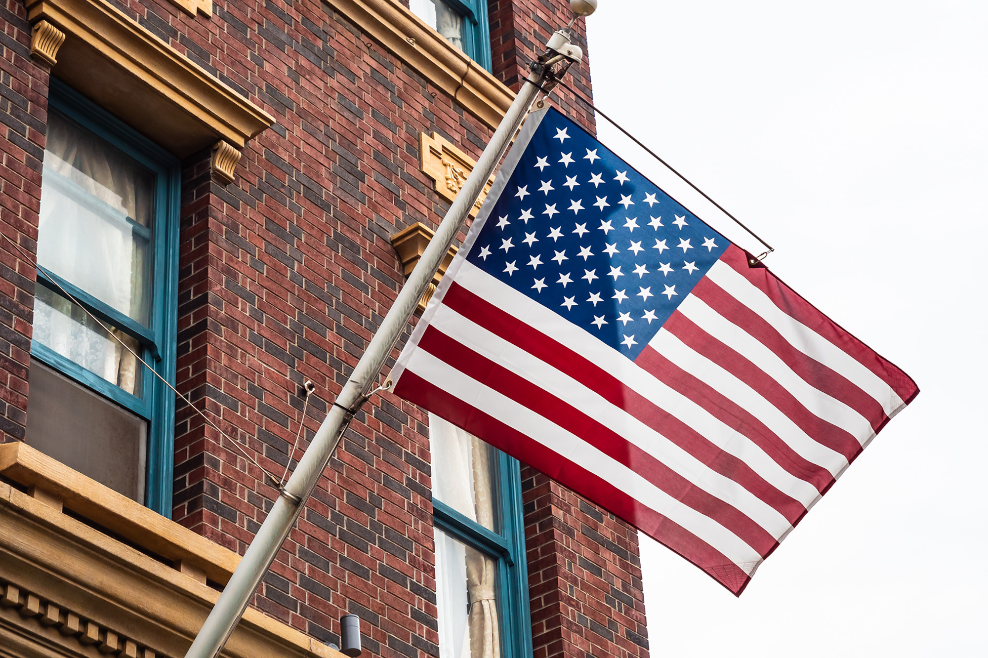American flag flying in front of red brick building.