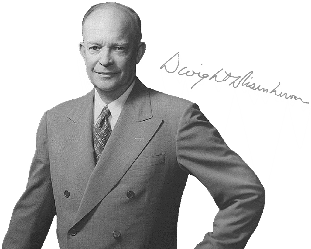 A black and white portrait of Dwight D. Eisenhower, dressed in a dark suit with a tie, posing with hands on hips. His autograph is in the corner of the photograph.