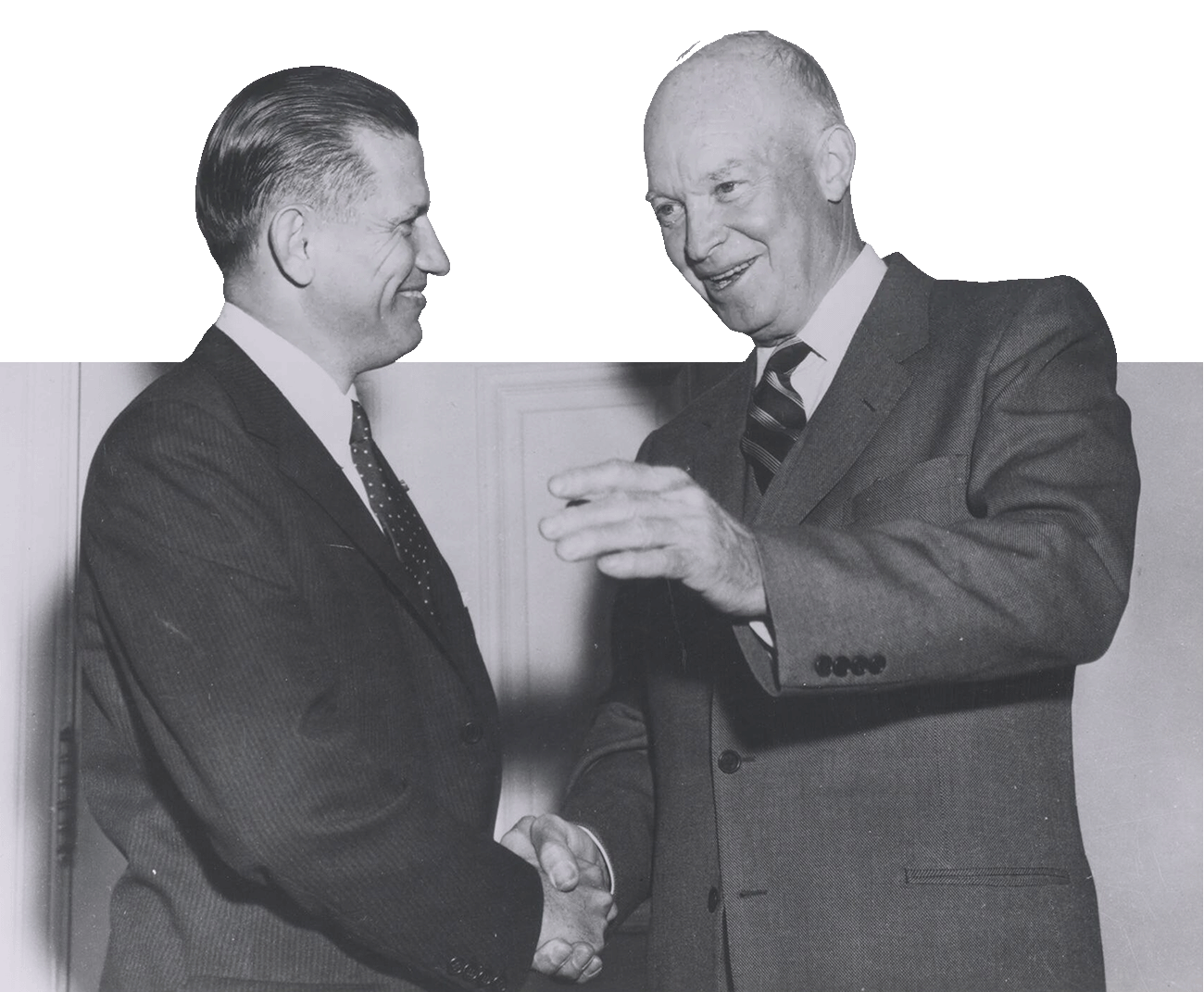 Dwight D. Eisenhower shaking hands with another man. Both are wearing suits and ties.