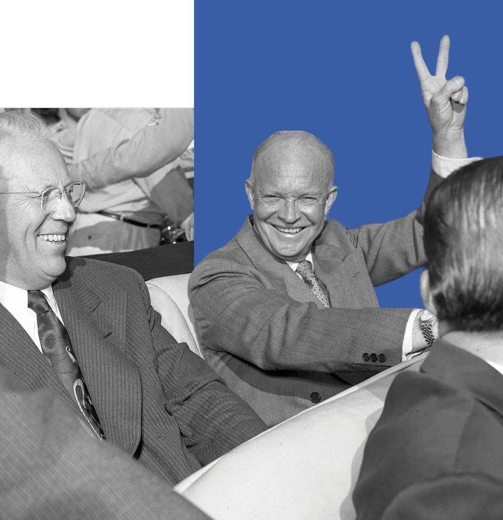 Two men in suits sitting in the backseat of a car, one giving a peace-sign gesture