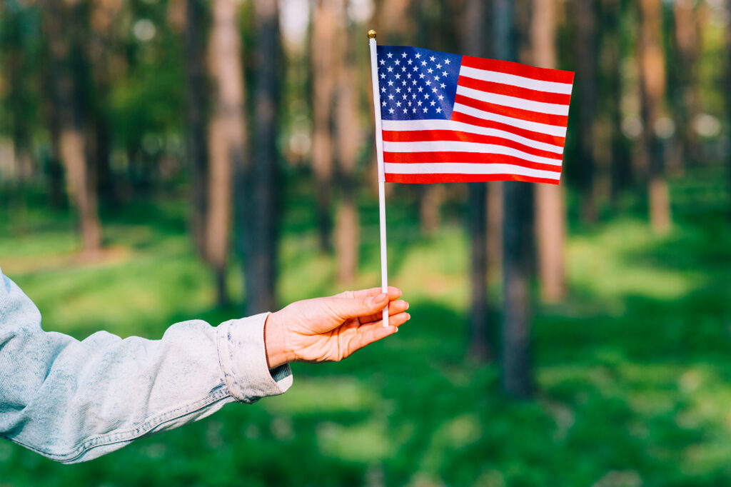 A person holds up an American flag.