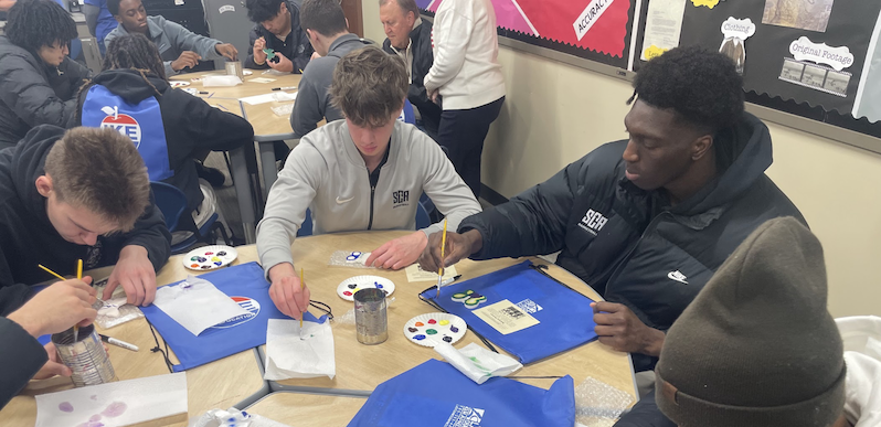 Students paint small craft pieces during a hands-on educational activity at the Eisenhower Foundation campus.