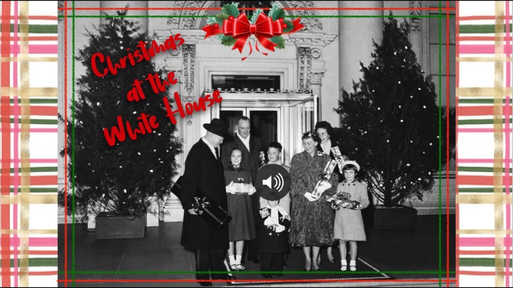 Black-and-white White House Christmas scene with people gathered near a decorated tree.