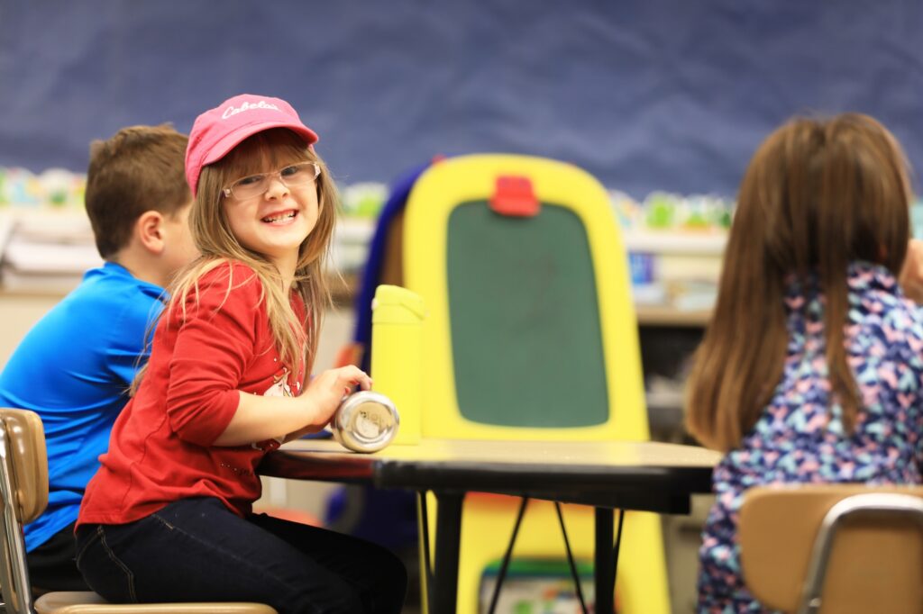 Child holding a brightly colored classroom project.