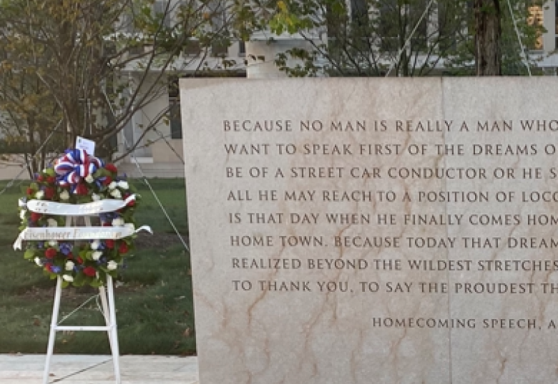Memorial wreath displayed beside an engraved plaque.