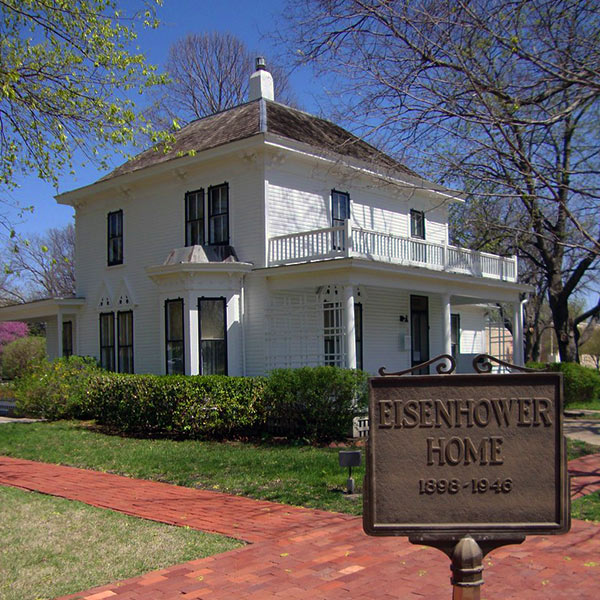 Eisenhower’s white two-story boyhood home with a brick walkway.