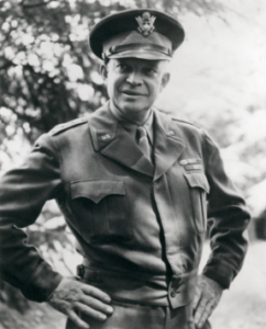 General Eisenhower standing outdoors with his hands on his hips.