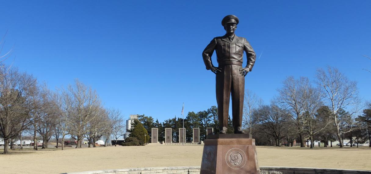 Bronze statue of a military leader beneath a blue sky.