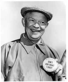 Smiling Eisenhower holding a campaign pin.