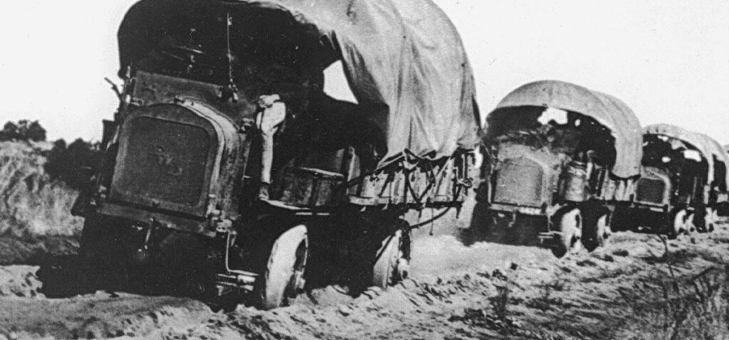 Canvas-covered military trucks struggle through deep mud during the 1919 transcontinental motor convoy.