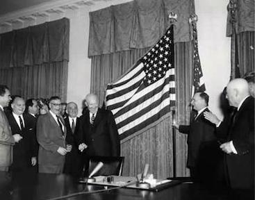 Dwight D. Eisenhower displays a newly designed American flag in 1959.