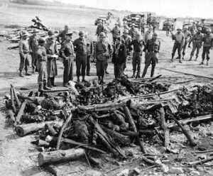 General Eisenhower and military officers inspecting rows of bodies at a liberated concentration camp.