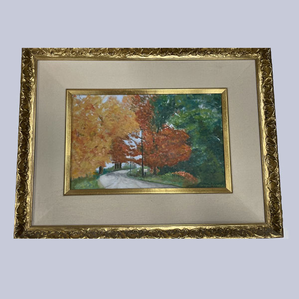 framed painting of an autumnal landscape scene, featuring trees in fall colors, with a path leading into the distance. The frame is ornate and appears to be a traditional style of framing art, suggesting a classic or traditional theme for the artwork.