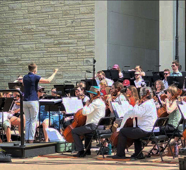 Orchestra musicians performing outdoors at Symphony at Sunset.