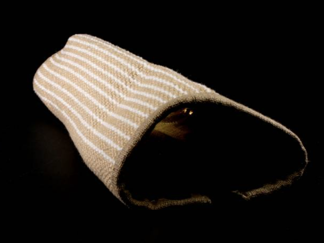 Padded striped training sleeve used during military dog handling exercises.
