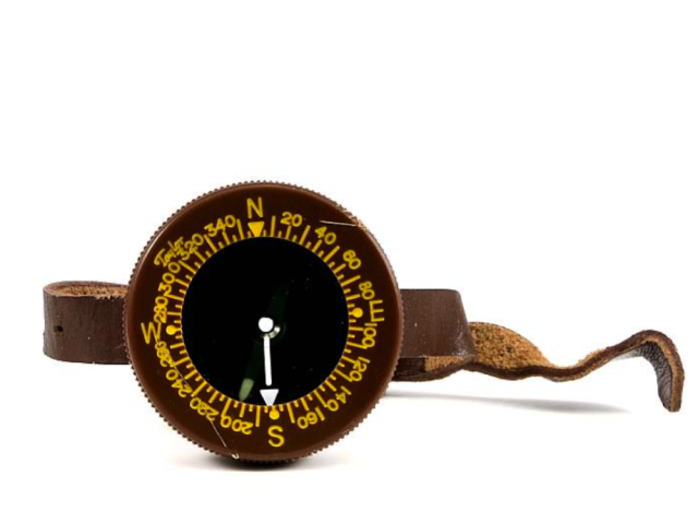 Black military wrist compass with yellow directional markings.