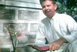 Man wearing a white shirt and tie while standing outdoors.