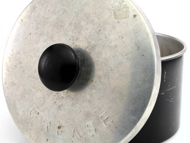 Round metal grease canister with a black cap.