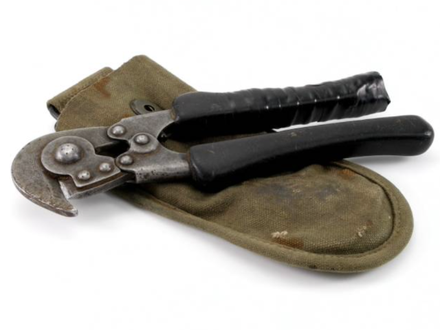 Military wire cutters resting on an olive-green fabric surface.