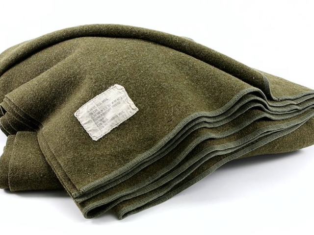 Folded olive-green military wool blanket with a sewn identification label.