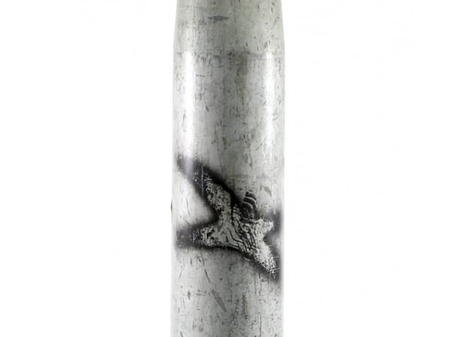 Close-up of a spent metal artillery shell casing.