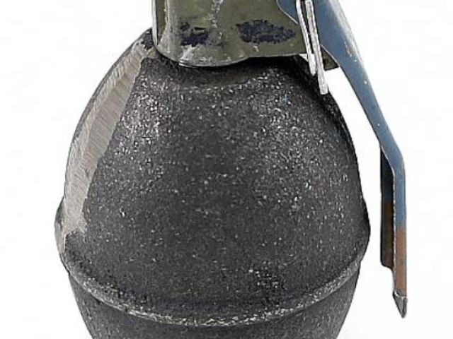 Dark metal lemon-shaped hand grenade with its safety lever and pin visible.