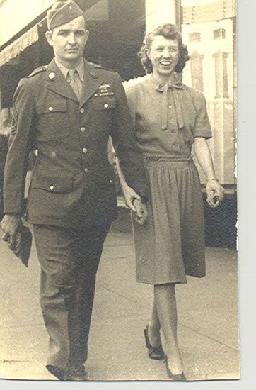 Serviceman and woman standing together outdoors.