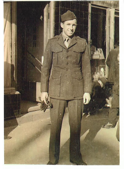 Serviceman standing outside a building in a military uniform.