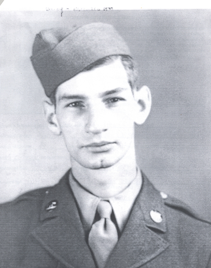 This is an old black and white photograph. It features a man who appears to be in military attire. He is wearing what looks like a military uniform. The person has short hair and is looking directly at the camera with a neutral expression.