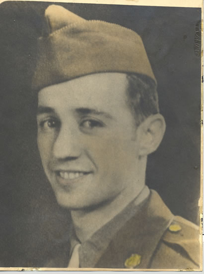 Smiling serviceman wearing a military uniform and garrison cap.