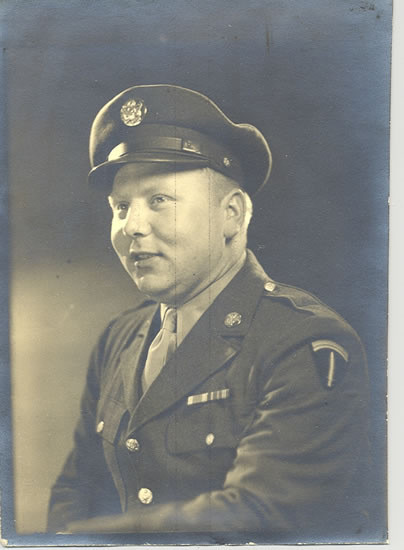 Serviceman wearing a decorated U.S. Army uniform and peaked cap.