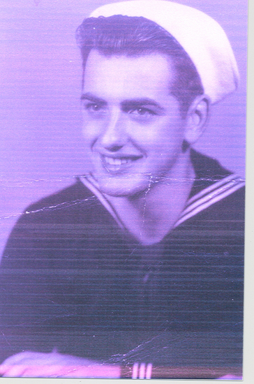 A sepia-toned photograph of a young man in a sailor's uniform smiling at the camera with a relaxed demeanor.