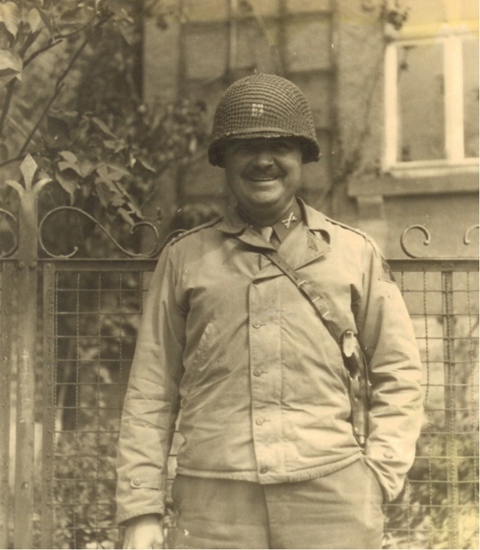 Serviceman standing outdoors in a helmet and field uniform.