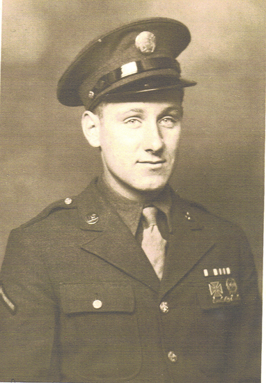 Serviceman wearing a military uniform and peaked cap.