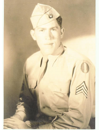 A black-and-white photograph of a man in military attire, featuring an emblem on his cap, posing for the camera set against a plain background.