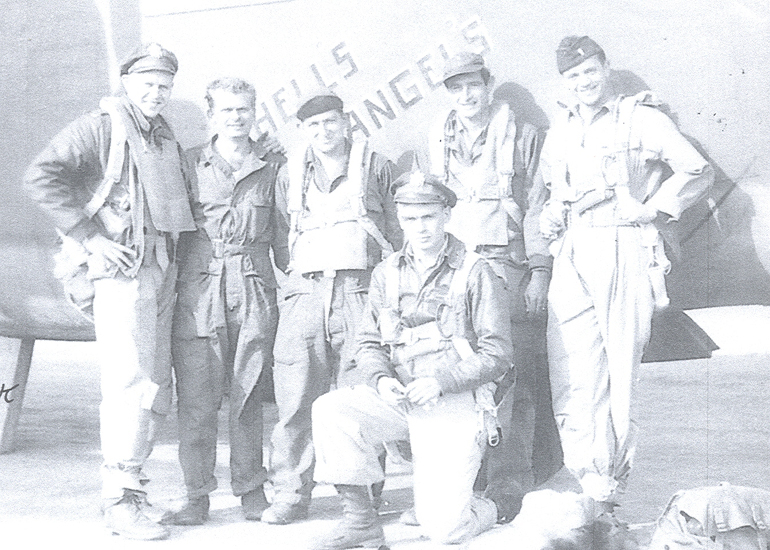 Group of servicemen posing together outdoors.