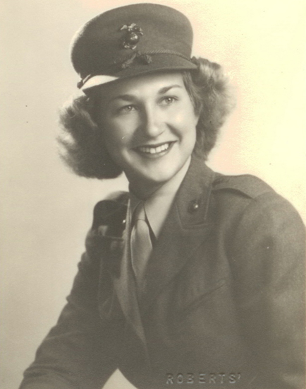 A woman in a military uniform smiles for a photograph.