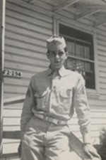 Bill Guarnere standing outside a building in military uniform.