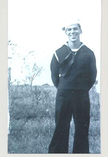 Sailor standing outdoors in a dark naval uniform.