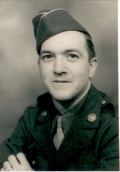 The image is a black-and-white photograph of a man in military attire. The individual has short hair and is wearing a tie.