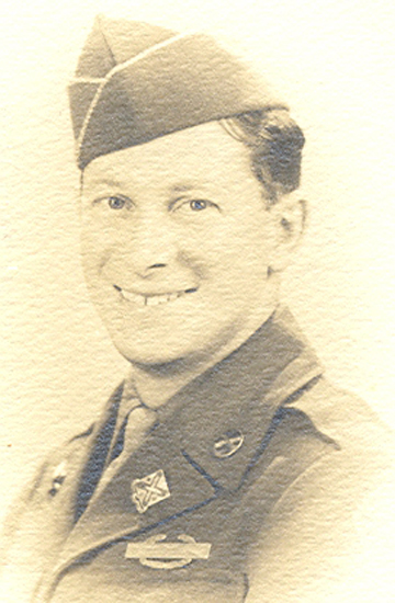 Smiling Kenneth D. Bourbina wearing a military garrison cap.