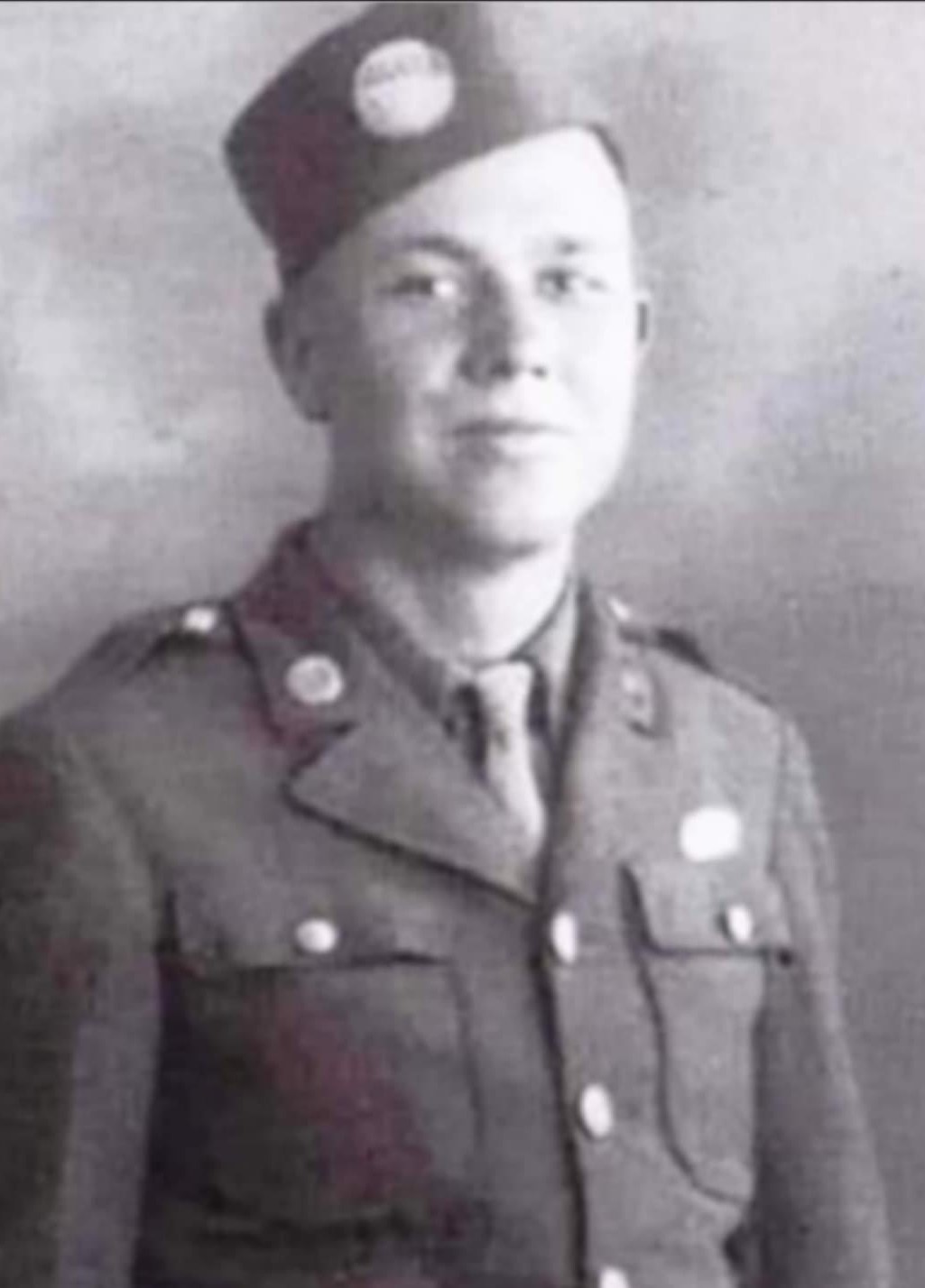 A man in military uniform, likely from an earlier time period, standing upright against a backdrop.