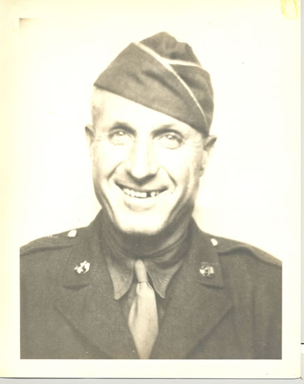 Smiling serviceman wearing a military uniform and garrison cap.