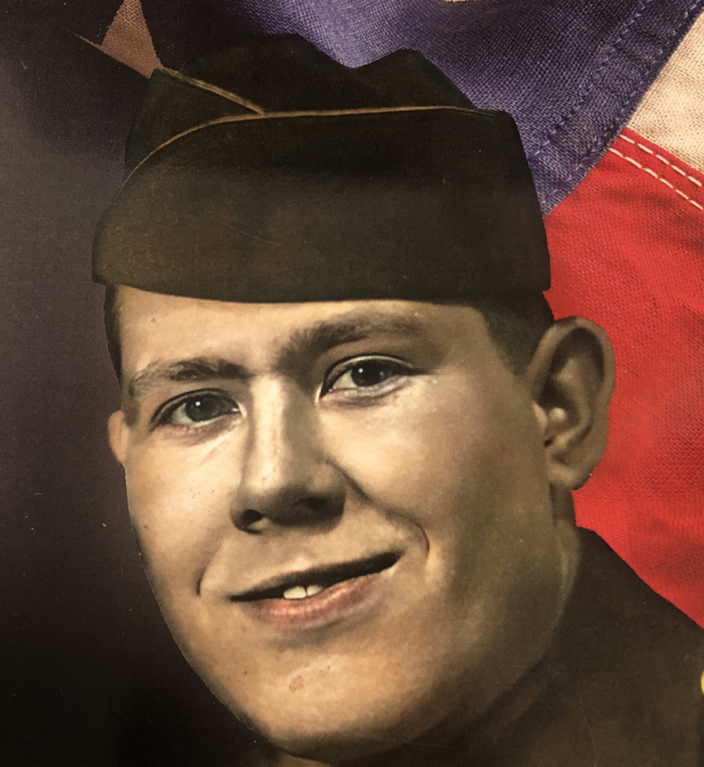 Old photograph of young man in military uniform, smiling.