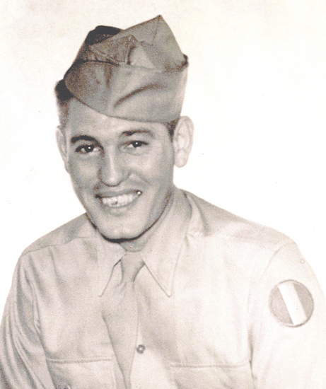 A young man in military uniform. He is smiling at the camera.