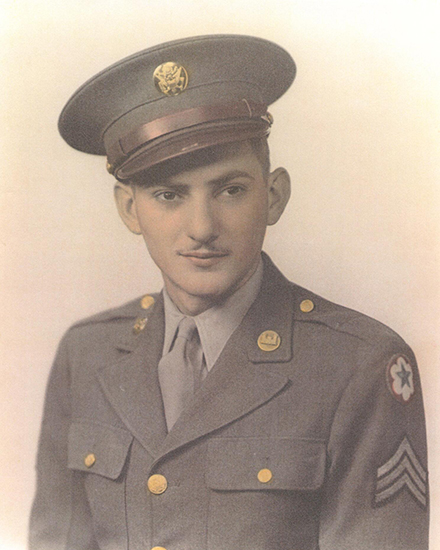 A black-and-white photograph of a young soldier in a uniform with a cap, wearing a tie.