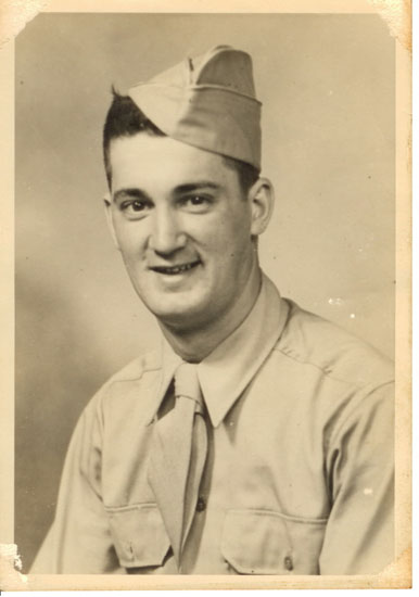 A black and white vintage photograph captures a moment featuring a man in military attire with a relaxed posture. He is dressed in an army uniform, complete with a tie.