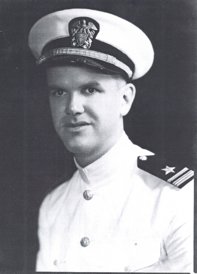 Naval officer wearing a white dress uniform and peaked cap.