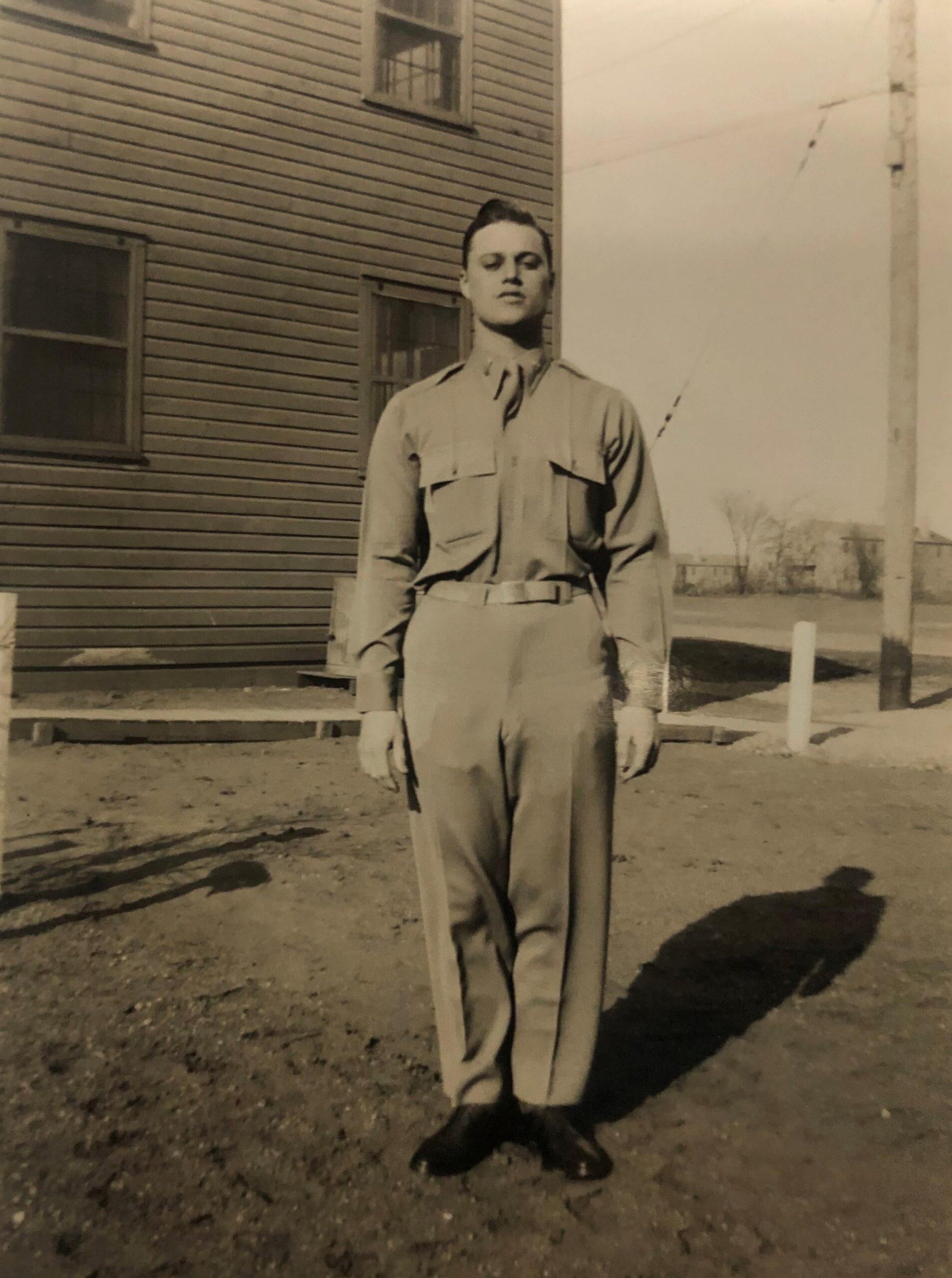Serviceman standing outside a building in a military uniform.