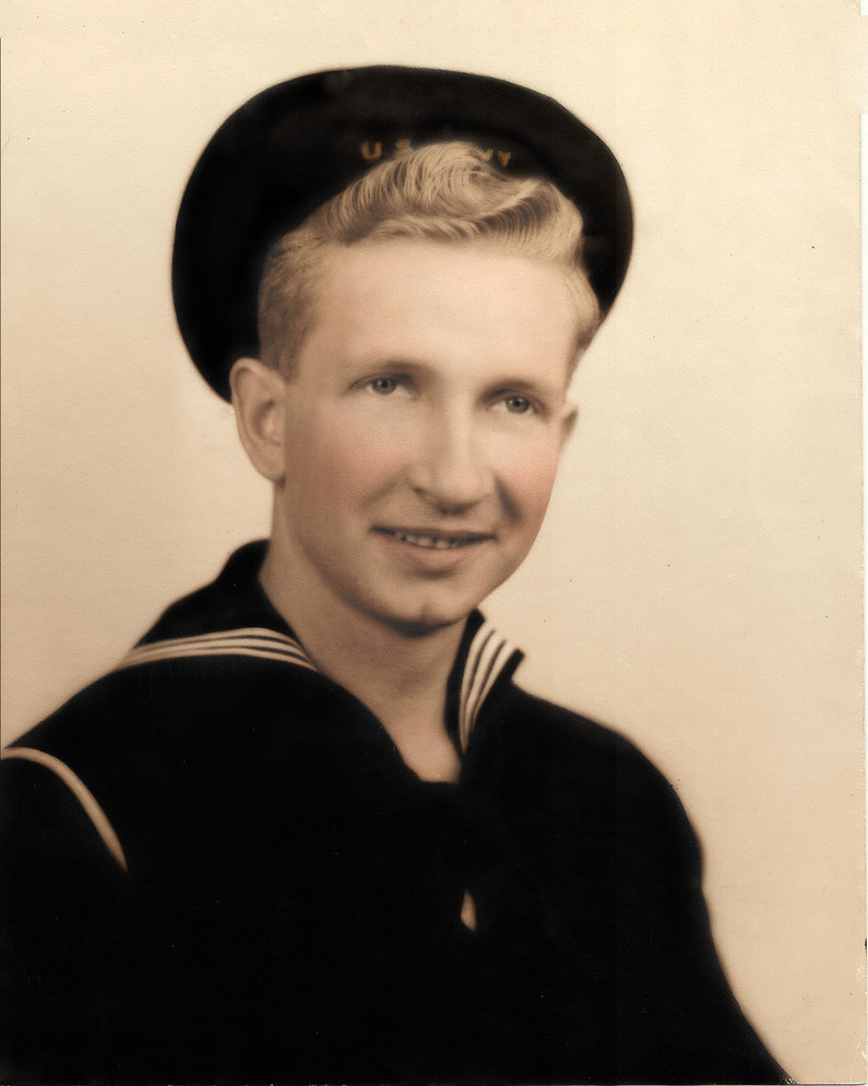 Robert Lewis Collins smiling in a U.S. Navy uniform and cap.
